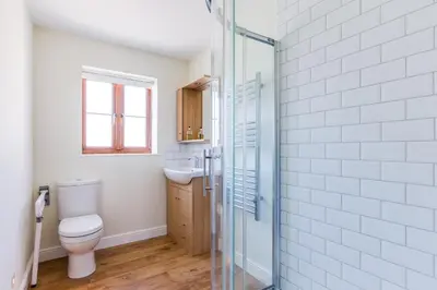 a bathroom with a toilet and a glass shower at Chy Pol in Wadebridge