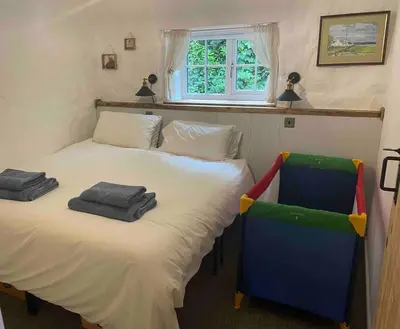 a bedroom with a bed with two towels on it at The Anvil, 2 bed cottage, in the heart of Cornwall in Gwennap