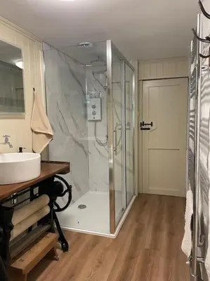 a bathroom with a glass shower and a sink at The Anvil, 2 bed cottage, in the heart of Cornwall in Gwennap