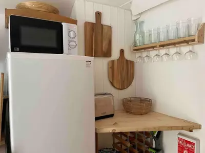 a microwave on top of a refrigerator in a kitchen at The Anvil, 2 bed cottage, in the heart of Cornwall in Gwennap