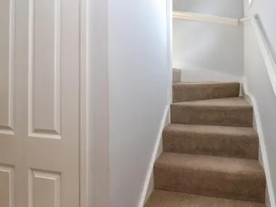 a stairway with a door leading up to a set of stairs at Primrose Cottage in Falmouth