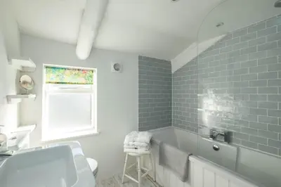 a bathroom with a sink and a bath tub at Mobray, Port Isaac Bay Holidays in Port Isaac