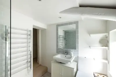 a white bathroom with a sink and a mirror at Mobray, Port Isaac Bay Holidays in Port Isaac