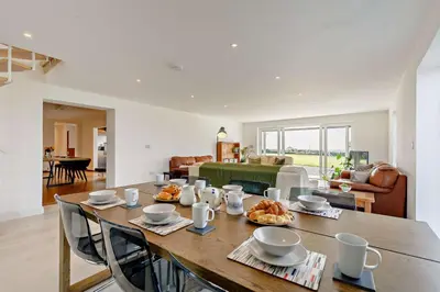 a dining room with a table and a living room at 5 Bed in St. Merryn oc-t27899 in St Merryn