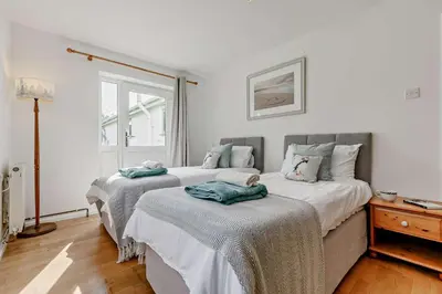 two beds in a room with white walls at 5 Bed in St. Merryn oc-t27899 in St Merryn