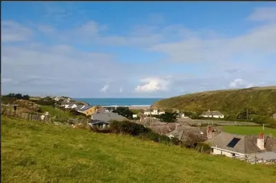 a view of a village with the ocean in the background at Seagulls Porthcothan Bay Cottage in Padstow