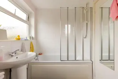 a white bathroom with a shower and a sink at Bed & Breakfast Only - not 24 hour lodging - Truro, Cornwall - free parking in Truro