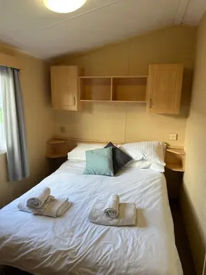 a bedroom with a bed with towels on it at Newquay Bay Porth Caravan - 8 Berth in Newquay