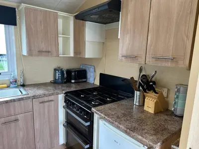 a kitchen with a stove and a counter top at Newquay Bay Porth Caravan - 8 Berth in Newquay