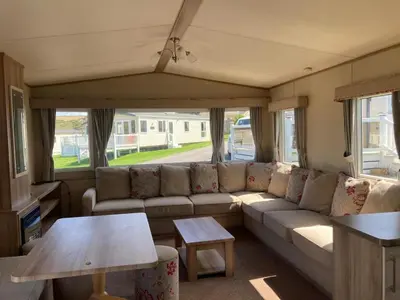 a living room with a couch and a table at NB166 - Porth Bay Hideaway in Porth