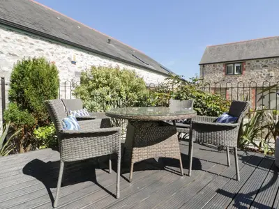 a patio with a table and chairs on a deck at Pirata in St Austell