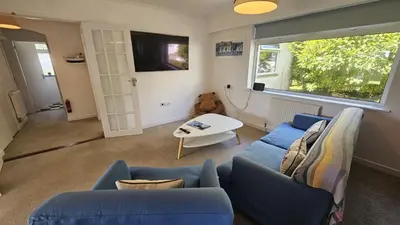 a living room with a blue couch and a table at Heathfield in Saint Mawes