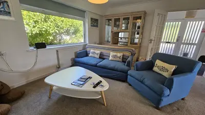a living room with two blue couches and a table at Heathfield in Saint Mawes