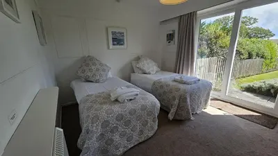 a small room with two beds and a window at Heathfield in Saint Mawes