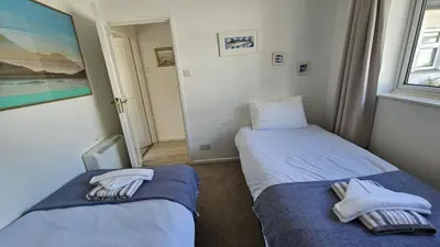 two beds in a small room with towels on them at Heathfield in Saint Mawes
