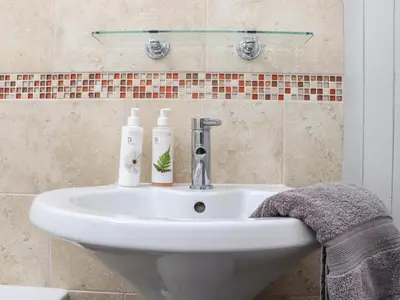 a bathroom sink with two bottles on it at Little Riviere in Hayle