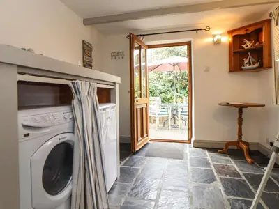 a kitchen with a washer and dryer in a room at Little Riviere in Hayle