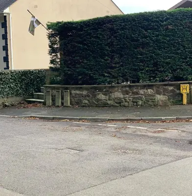 a wall with a flag on it next to a street at Saint Chads Lodge Near EDEN Luxulyan in Luxulyan