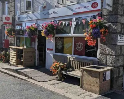 a shop with a bench in front of it at Saint Chads Lodge Near EDEN Luxulyan in Luxulyan