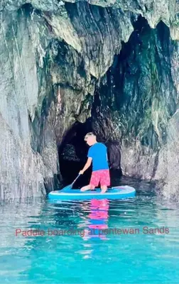 a man on a paddle board in a cave at Saint Chads Lodge Near EDEN Luxulyan in Luxulyan