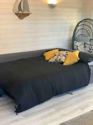 a large black bed with yellow pillows in a room at Saint Chads Lodge Near EDEN Luxulyan in Luxulyan