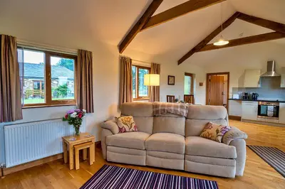 a living room with a couch and a table at Finest Retreats - The Shippon at Lestitha in Liskeard