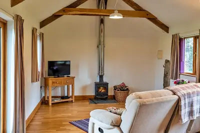 a living room with a couch and a stove at Finest Retreats - The Shippon at Lestitha in Liskeard