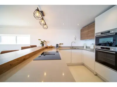 a kitchen with white cabinets and a counter top at Gwel An Keynvor Penthouse in Newquay