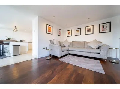 a living room with a couch and a kitchen at Gwel An Keynvor Penthouse in Newquay