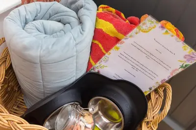 a basket with towels and a thermometer and a note at Carines Barns - Tre in Newquay