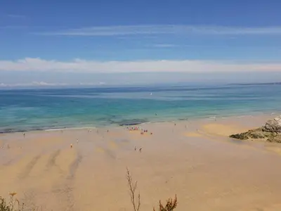 a group of people on a beach near the ocean at Carines Barns - Tre in Newquay