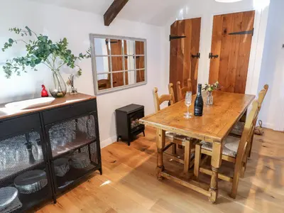 a dining room with a wooden table and chairs at Carines Barns - Pol in Newquay