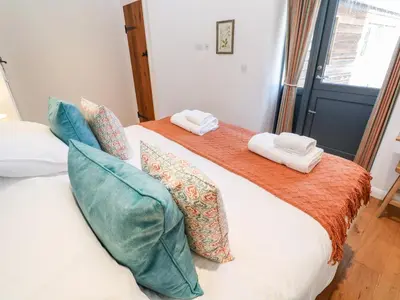a bedroom with two beds with towels on them at Carines Barns - Pol in Newquay