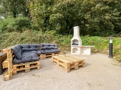 a couch and a table and a stove at Carines Barns - Pol in Newquay