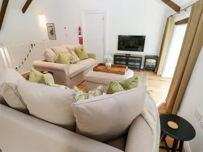 a living room with two couches and a tv at Carines Barns - Par in Newquay