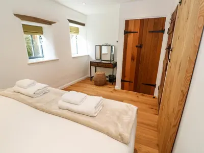 a bedroom with a bed with two towels on it at Carines Barns - Par in Newquay
