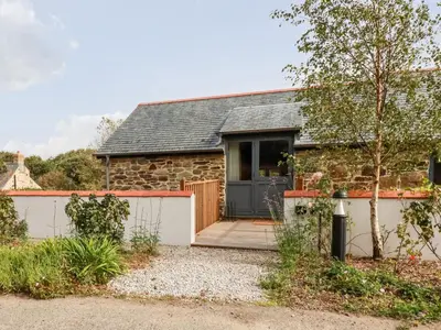 a stone cottage with a blue door at Carines Barns - Par in Newquay