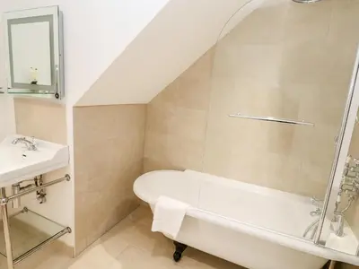 a bathroom with a bath tub and a sink at Carines Barns - Par in Newquay