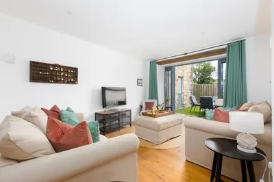 a living room with a couch and a tv at Carines Barns - Pen in Newquay
