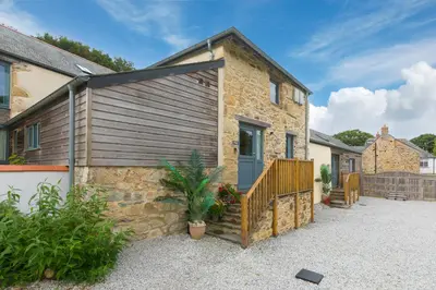 a stone house with a blue door at Carines Barns - Pen in Newquay