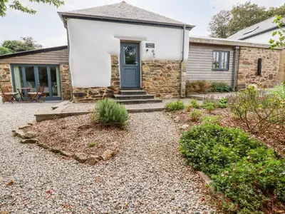 a stone house with a blue door at Carines Barns - Wesley Barn in Newquay