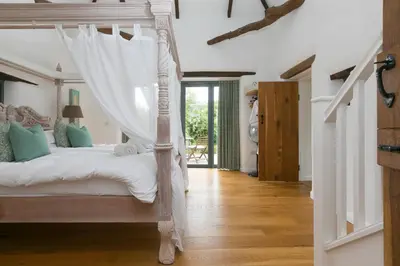 a bedroom with a bed with a canopy at Carines Barns - Wesley Barn in Newquay
