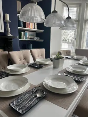 a dining room table with white plates on it at The Captain's House in Looe