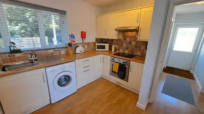a kitchen with a sink and a washing machine at Polmaro in Saint Mawes