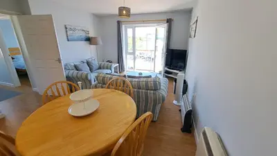 a living room with a table and a couch at Polmaro in Saint Mawes