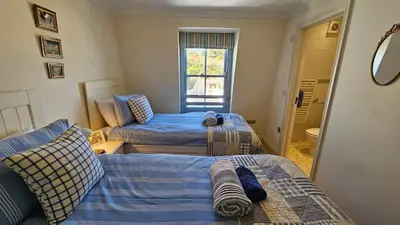 a bedroom with two beds and a bathroom at Pennant in Saint Mawes