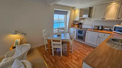 a kitchen with a table and a dining room at Pennant in Saint Mawes