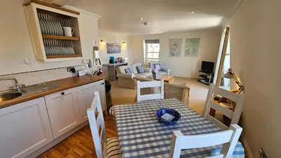 a kitchen and living room with a table and chairs at Pennant in Saint Mawes