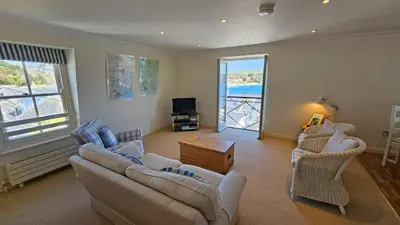a living room with a couch and chairs and a television at Pennant in Saint Mawes