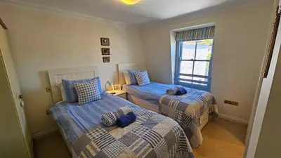 a bedroom with two beds and a window at Pennant in Saint Mawes
